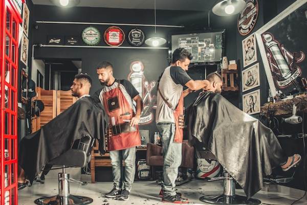 BarberShop and Hair Salon: Barber giving a haircut in a trendy barbershop and hair salon.